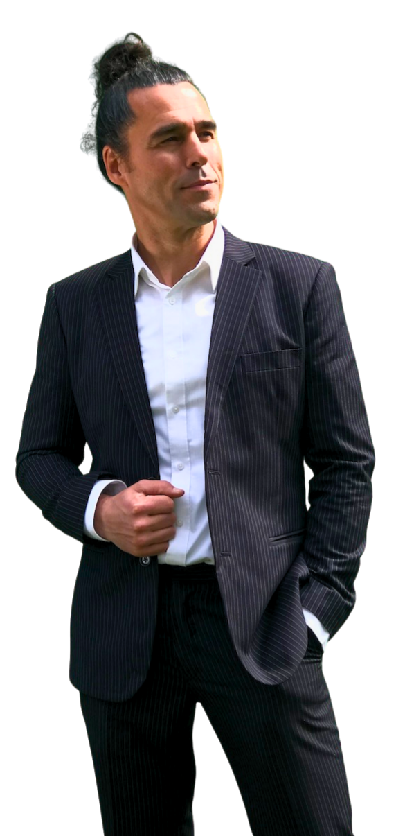 a photo of Davido, the English teacher dressed in a dark pin-striped suit and a white shirt. His hair is done up in a tight coil on the top of his head. He's holding his jacket with the right hand whilst he's smiling and looking to the right, to the area of content.