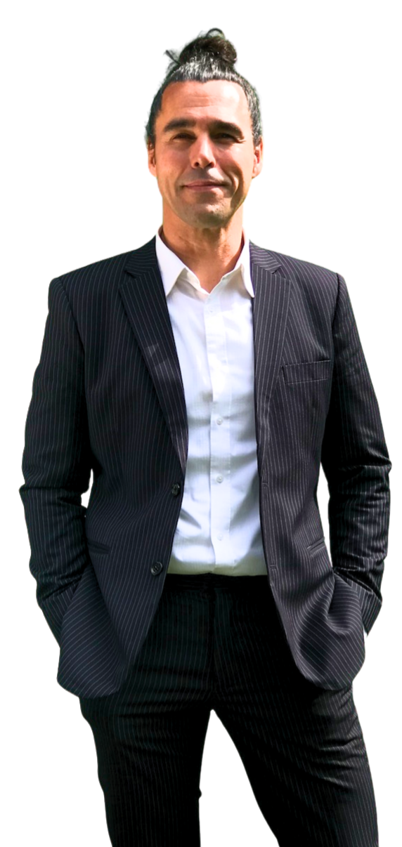 a photo of Davido, the English teacher dressed in a dark pin-striped suit and a white shirt. His hair is done up in a tight coil on the top of his head. He's holding his jacket with the right hand whilst he's smiling and looking to the right, to the area of content.