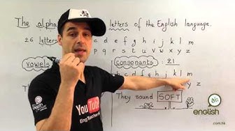 An English class in Hong Kong on the alphabet by a teacher with a cap in front of a whiteboard